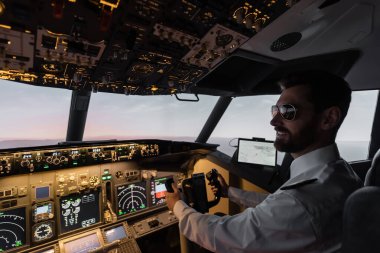 Akşamları pilotluk yaparken boyunduruk takan güneş gözlüklü neşeli pilot. 