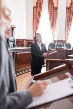 Esmer tanık dava sırasında bulanık avukata bakıyor.