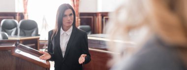 prosecutor talking to blurred witness during questioning in trial, banner clipart
