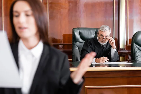 Grauhaarige Richterin Justiert Ihre Brille Während Sie Den Staatsanwalt Verschwommenen — Stockfoto
