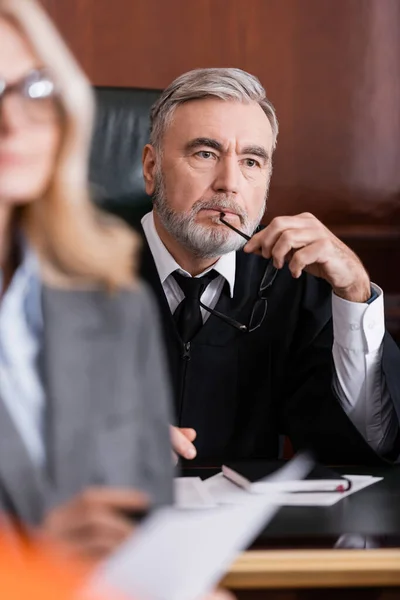 Nachdenklicher Richter Mit Brille Der Nähe Des Verteidigers Auf Verschwommenem — Stockfoto