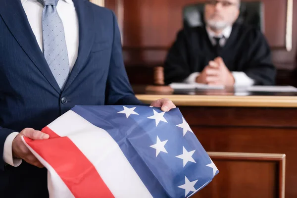 在法庭上高举美国国旗的诉讼律师接近资深法官 背景模糊 — 图库照片