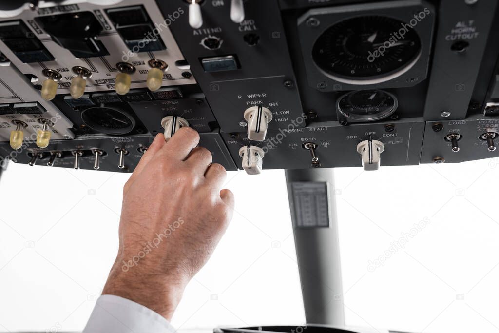 cropped view of pilot using switcher on overhead panel in airplane simulator 