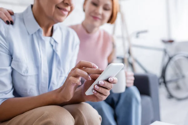 Mulher Sorrindo Mensagens Telefone Celular Perto Namorada Lésbica Borrada — Fotografia de Stock