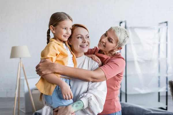 Veselá Lesbička Objímající Přítelkyni Adoptovanou Dcerou Novém Domově — Stock fotografie