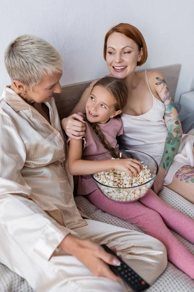 Lesbian Couple Hugging Kid Holding Remote Controller Bed — Stock Photo, Image