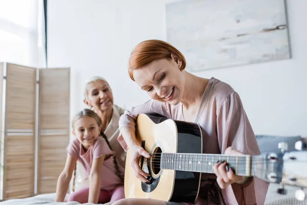 Mujer Lesbiana Positiva Tocando Guitarra Acústica Cerca Novia Borrosa Niño — Foto de Stock