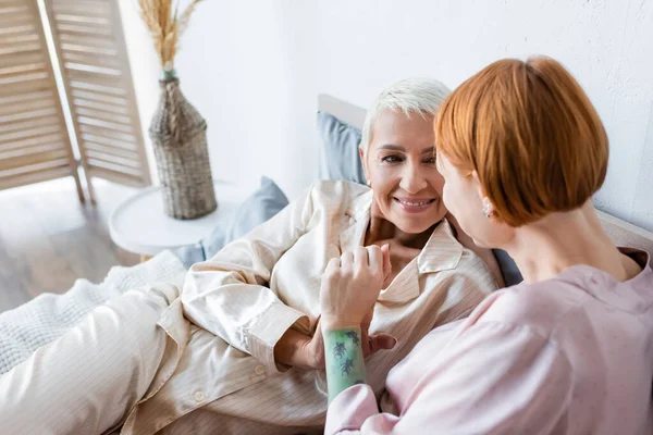 Mulher Sorridente Pijama Segurando Mão Namorada Cama Casa — Fotografia de Stock