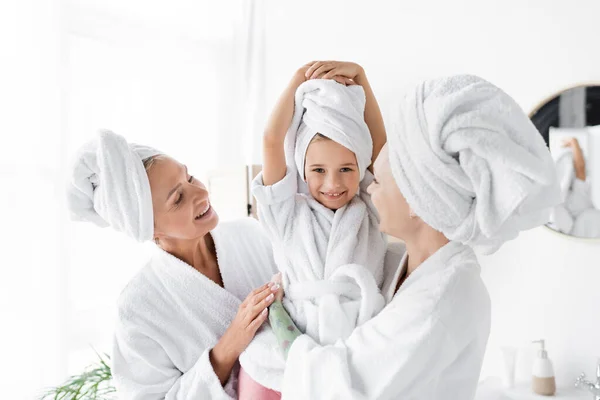 Alegre Lesbianas Albornoces Sosteniendo Niño Toalla Baño — Foto de Stock