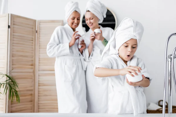 Amazed Girl Bathrobe Holding Cosmetic Cream Blurred Mothers Bathroom — Stock Photo, Image