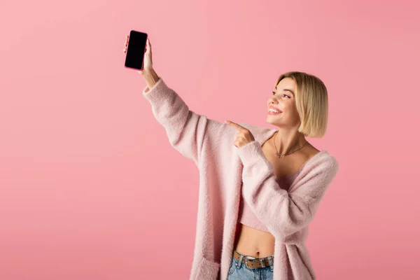 Happy Young Woman Soft Cardigan Pointing Smartphone Blank Screen Isolated — Stock Photo, Image