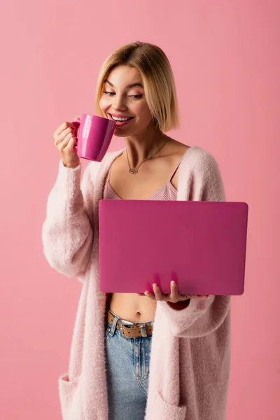 Usmívající Mladá Žena Drží Hrnek Kávou Notebookem Izolované Růžové — Stock fotografie