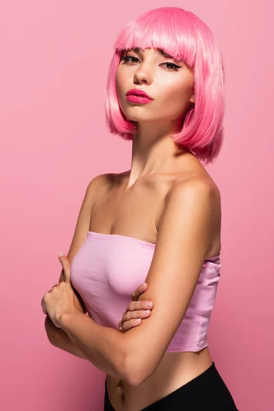 young woman with colored hair looking at camera isolated on pink