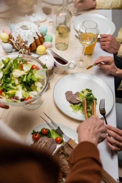 Vista Recortada Familia Cerca Ensalada Verduras Pastel Pascua Mesa Servida — Foto de Stock