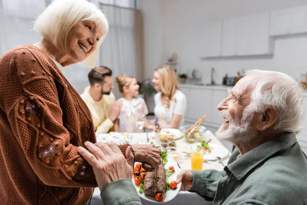 Smiling Woman Holding Fried Meat Senior Husband Family Dinner — Stock Photo, Image