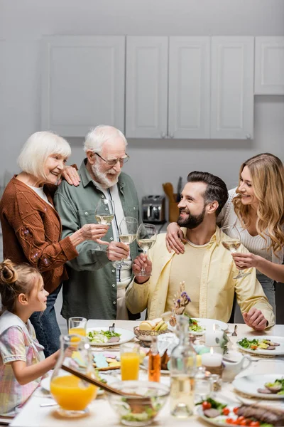 Família Feliz Clinking Copos Vinho Perto Mesa Servida Com Jantar — Fotografia de Stock