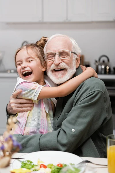 Excitada Chica Con Los Ojos Cerrados Abrazando Feliz Abuelo Durante — Foto de Stock