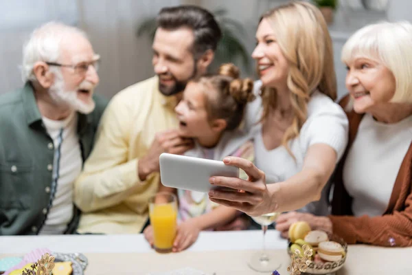 Mujer Borrosa Tomando Selfie Con Familia Alegre Durante Cena Pascua — Foto de Stock