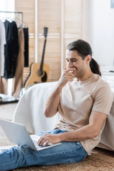 Hombre Feliz Con Pelo Largo Riendo Mientras Usa Ordenador Portátil — Foto de Stock