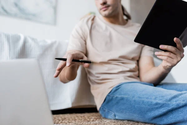 Cropped View Blurred Man Holding Notebook Pen Laptop Bedroom — Stock Photo, Image