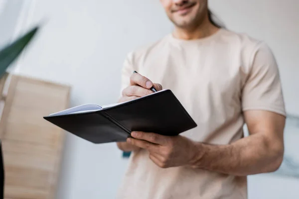 Beskärd Över Leende Man Hålla Anteckningsbok Och Penna — Stockfoto