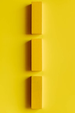 top view of colored blocks in vertical line on yellow background clipart