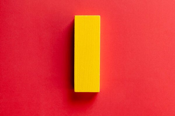 top view of rectangular yellow block on red background