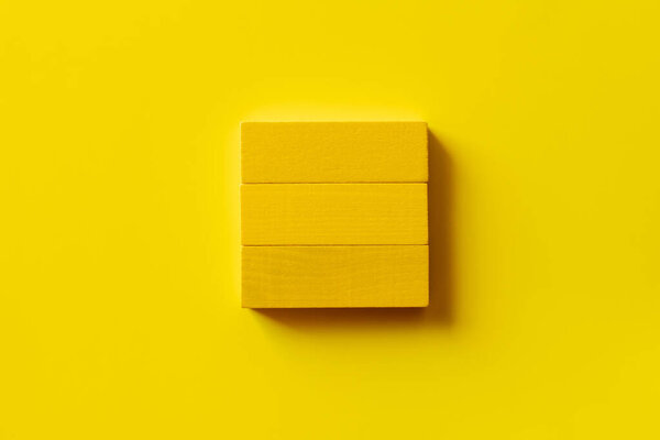 top view of square made of rectangular blocks on yellow background