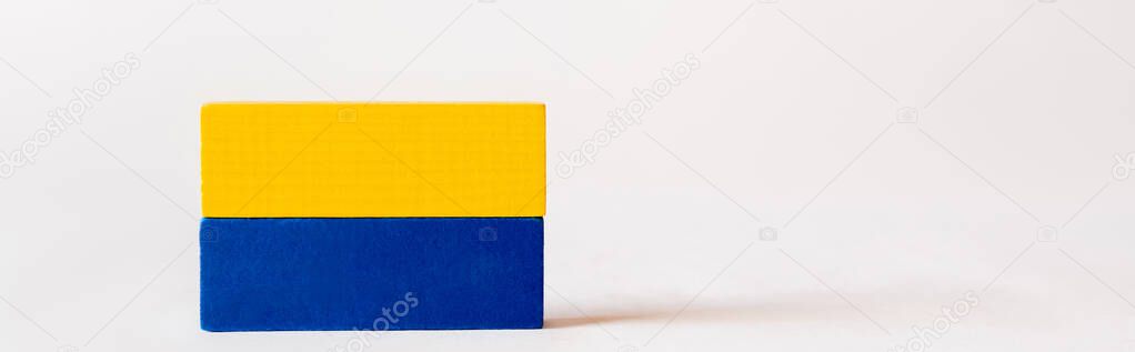 blue and yellow quadrangular blocks on white background with copy space, ukrainian concept, banner
