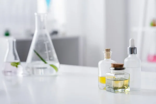 Bottiglia Con Oli Essenziali Vicino Siero Fiaschette Laboratorio — Foto Stock