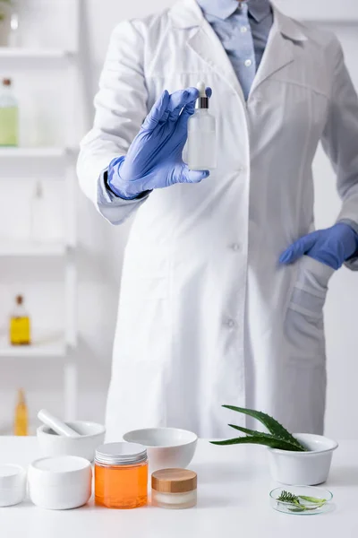 Cropped View Laboratory Assistant Latex Gloves Holding Bottle Serum Standing — Stock Photo, Image