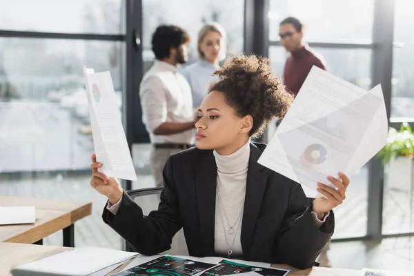 Joven Mujer Negocios Afroamericana Sosteniendo Papeles Mientras Trabaja Oficina —  Fotos de Stock