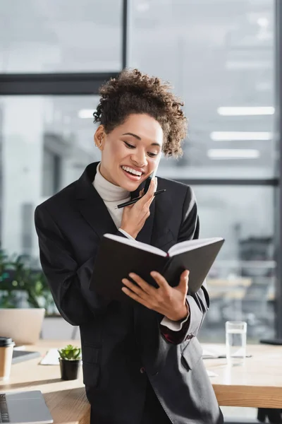 Pengusaha Wanita Afrika Positif Memegang Notebook Dan Berbicara Smartphone Kantor — Stok Foto