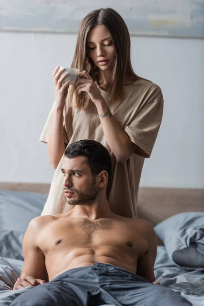 Brunette Woman Shirt Holding Cup Coffee Looking Muscular Boyfriend Bed — Stock Photo, Image