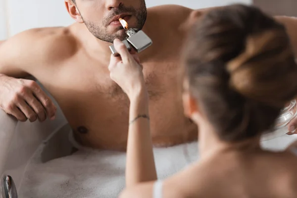 Young Woman Holding Lighter Muscular Boyfriend Cigarette Bathtub — Stock Photo, Image