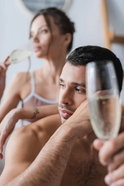 Gespierde Man Met Wazig Glas Champagne Buurt Van Vriendin Thuis — Stockfoto