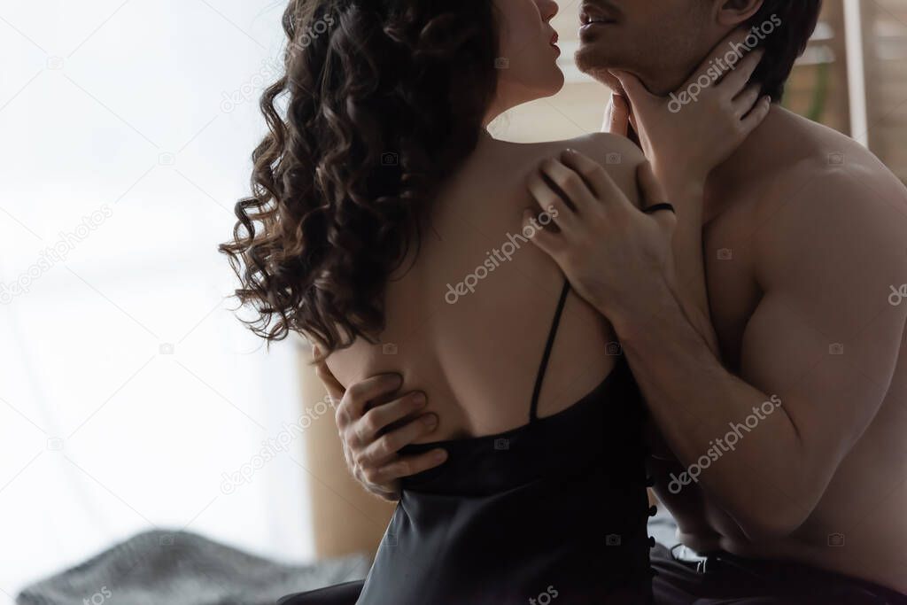 cropped view of sexy woman choking shirtless man 