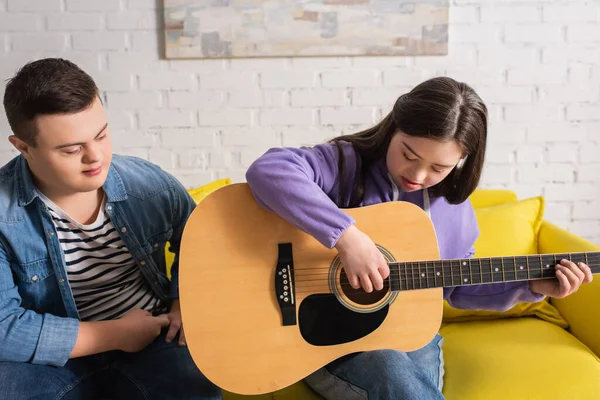 Chica Con Síndrome Tocando Guitarra Acústica Cerca Amigo Sofá Casa — Foto de Stock