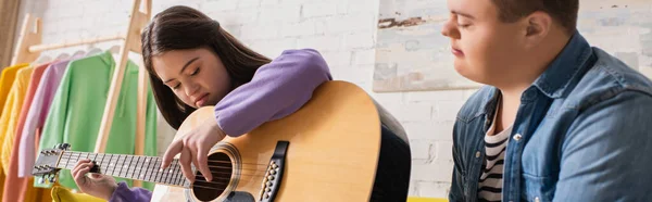 Adolescente Com Síndrome Tocando Guitarra Acústica Perto Amigo Borrado Casa — Fotografia de Stock