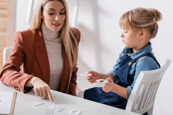 Terapeuta Del Habla Apuntando Carta Mesa Cerca Del Niño Sala — Foto de Stock