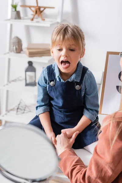 Kind Praten Buurt Wazig Spiegel Logopedist Met Klembord Spreekkamer — Stockfoto