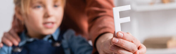 Размытые девушка и логопед держа письмо в классе, баннер 