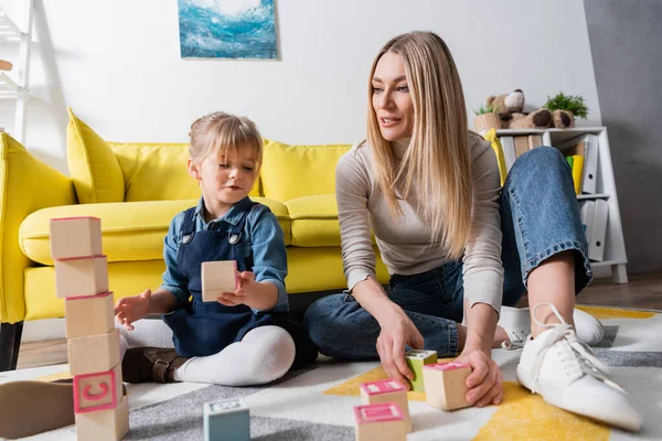 Speech Therapist Holding Wooden Blocks Letters Girl Floor Consulting Room — Stock Photo, Image