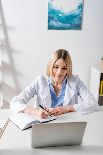 Positive Speech Therapist Writing Notebook Video Call Laptop Consulting Room — Stock Photo, Image