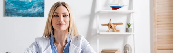 Logopedist White Coat Looking Camera Consulting Room Banner — Stock Photo, Image