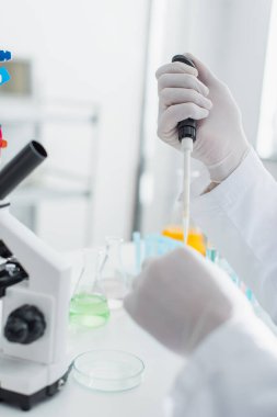 Mikro pipetli biyo-mühendisin mikroskop altında çalışırken çekilmiş görüntüsü