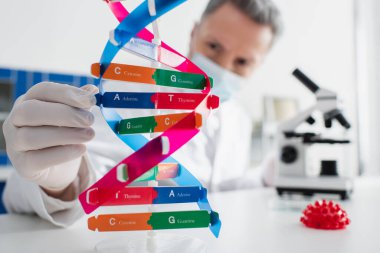 DNA ve koronavirüs bakteri modelleri tıbbi maskeli bulanık genetikçi yakınlarında