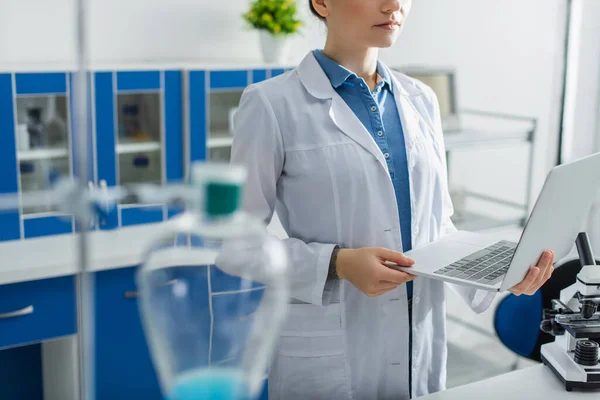 Vista Cortada Cientista Segurando Laptop Laboratório Primeiro Plano Desfocado — Fotografia de Stock