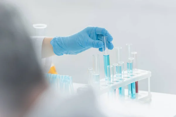Teilansicht Des Genetikers Reagenzglas Mit Blauer Flüssigkeit Auf Unscharfem Vordergrund — Stockfoto