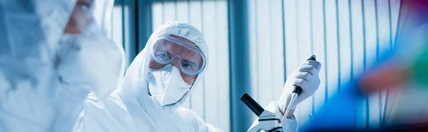 Wetenschapper Bril Medisch Masker Buurt Van Microscoop Collega Wazig Voorgrond — Stockfoto